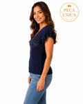 Modelo vestindo blusa BAZAR OFICIAL EFATA azul-marinho de tricô rendado com mangas curtas de babado e barra canelada.