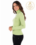 Modelo vestindo blusa de tricô verde claro de gola alta e manga longa da marca Morena Rosa, vista de perfil.