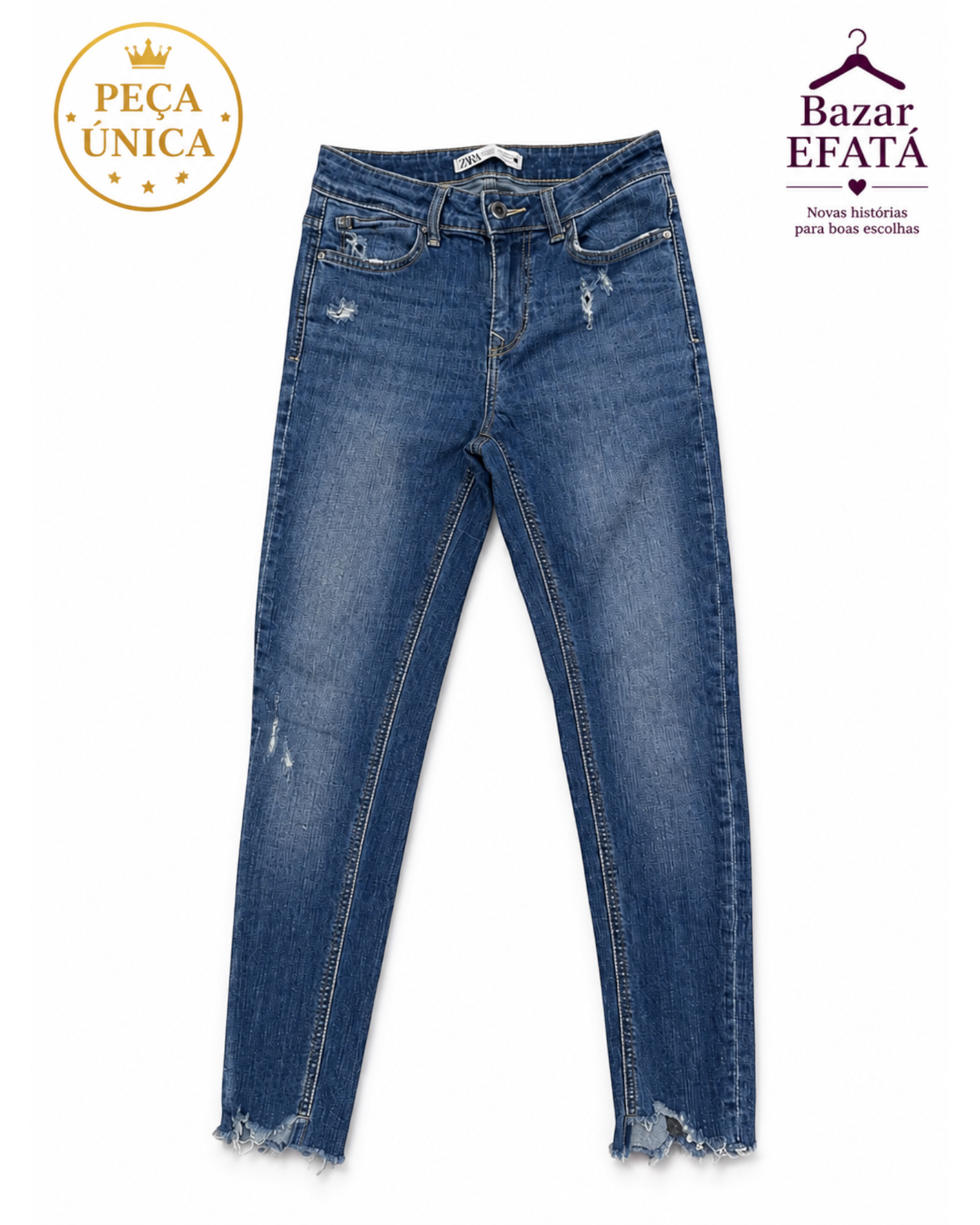 Calça jeans feminina BAZAR OFICIAL EFATA skinny azul com detalhes destroyed e barra desfiada em fundo branco.
