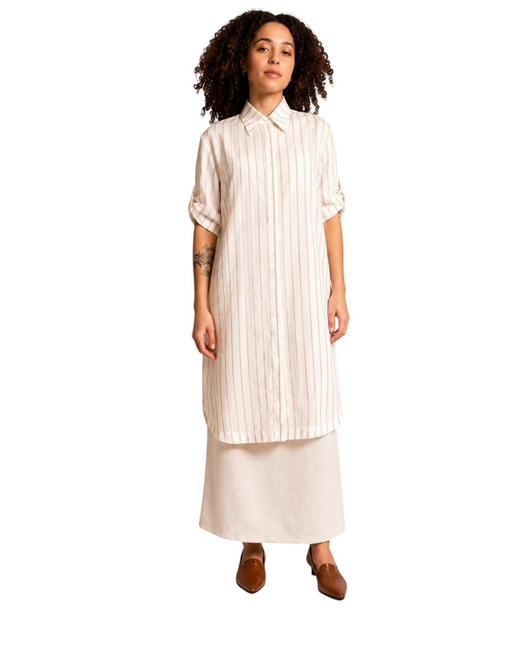 Modelo veste camisa alongada BAZAR OFICIAL EFATA off white com listras bege, gola clássica e mangas 3/4 ajustáveis.