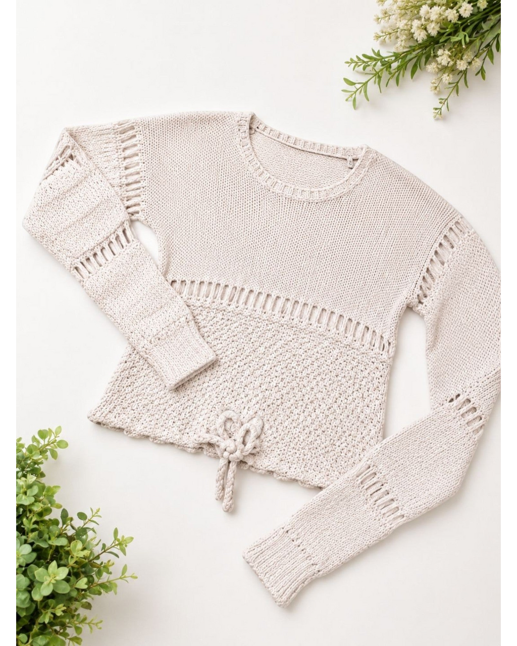 Suéter feminino BAZAR OFICIAL EFATA em tricô bege com detalhes vazados, gola redonda, manga longa e amarração na barra.