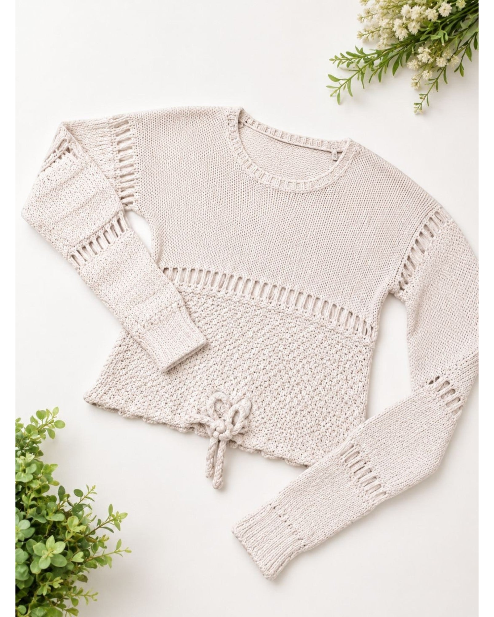 Suéter feminino BAZAR OFICIAL EFATA em tricô bege com detalhes vazados, gola redonda, manga longa e amarração na barra.