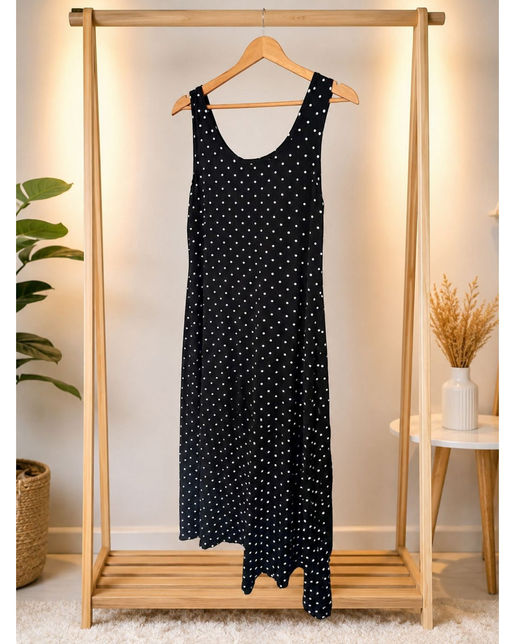 Vestido longo BAZAR OFICIAL EFATA preto com estampa de poá branco, alças largas e decote arredondado em cabide de madeira.