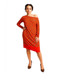 Modelo veste vestido BAZAR OFICIAL EFATA vermelho ombro a ombro com estampa de correntes douradas e barra assimétrica.